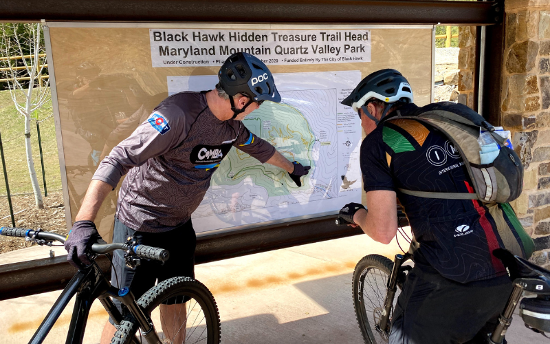 "Members of COMBA/BMA looking at a trailhead map"