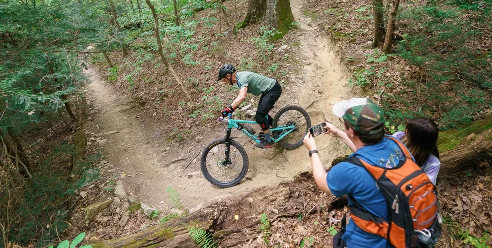 A racer riding down a trail while spectators watch