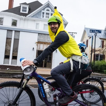 Kyle Lawrence riding a mountain bike in a banana costume